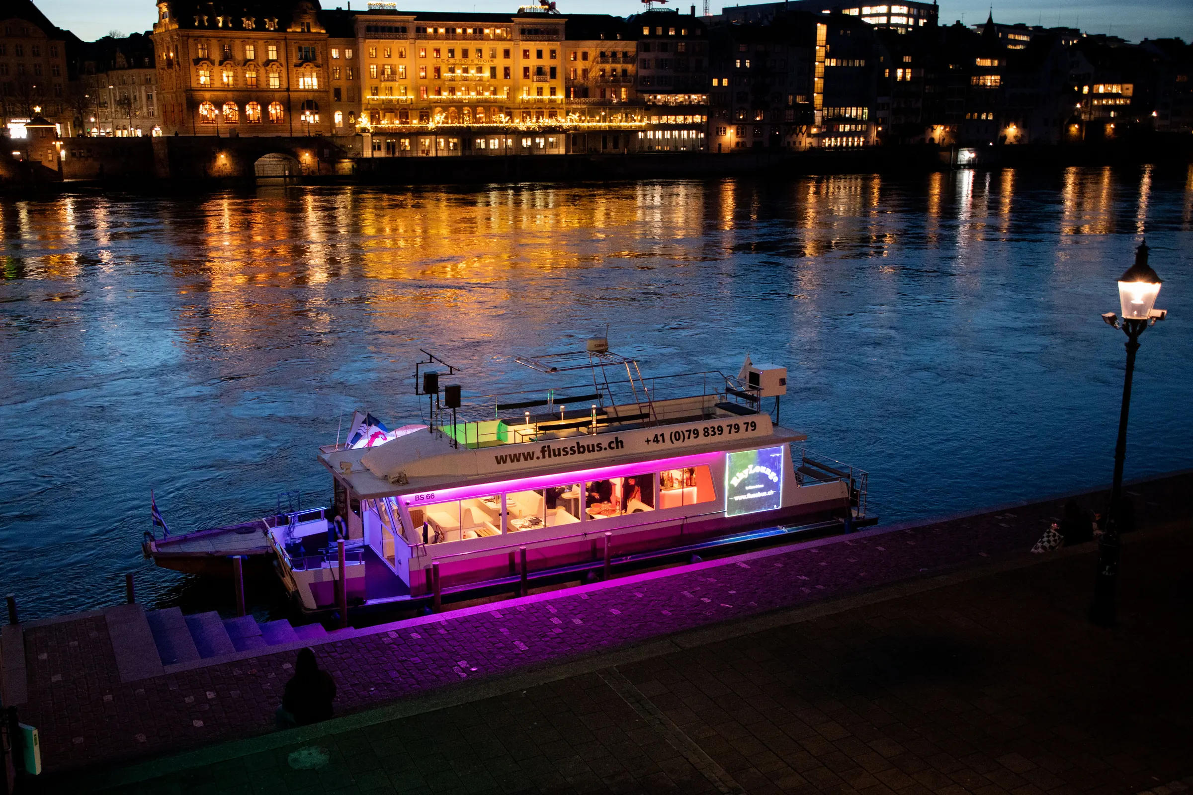 Die beleuchtete RhyLounge am Basler Rheinufer